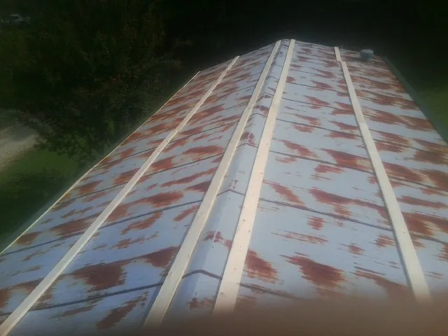 Rusted metal roof panels with new wood purlins before replacement — Storm Damage Roof Repair in Noonan by Roofing Brothers