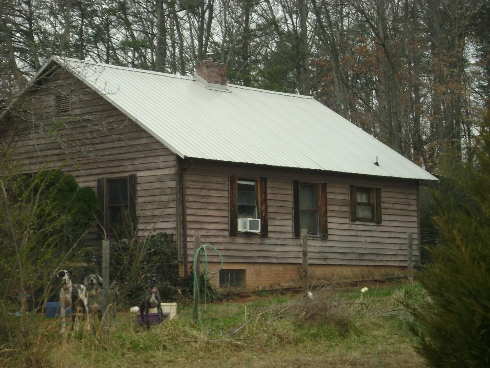 White metal roof on an old wood sided farmhouse, from a Metal Roof Installation job in Noonan